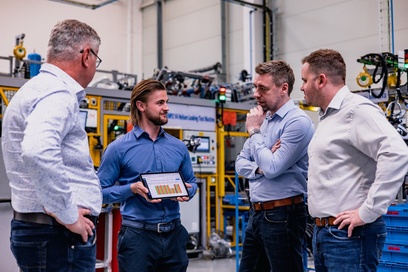 Tým u výrobní linky s OEE dashboardem na tabletu
