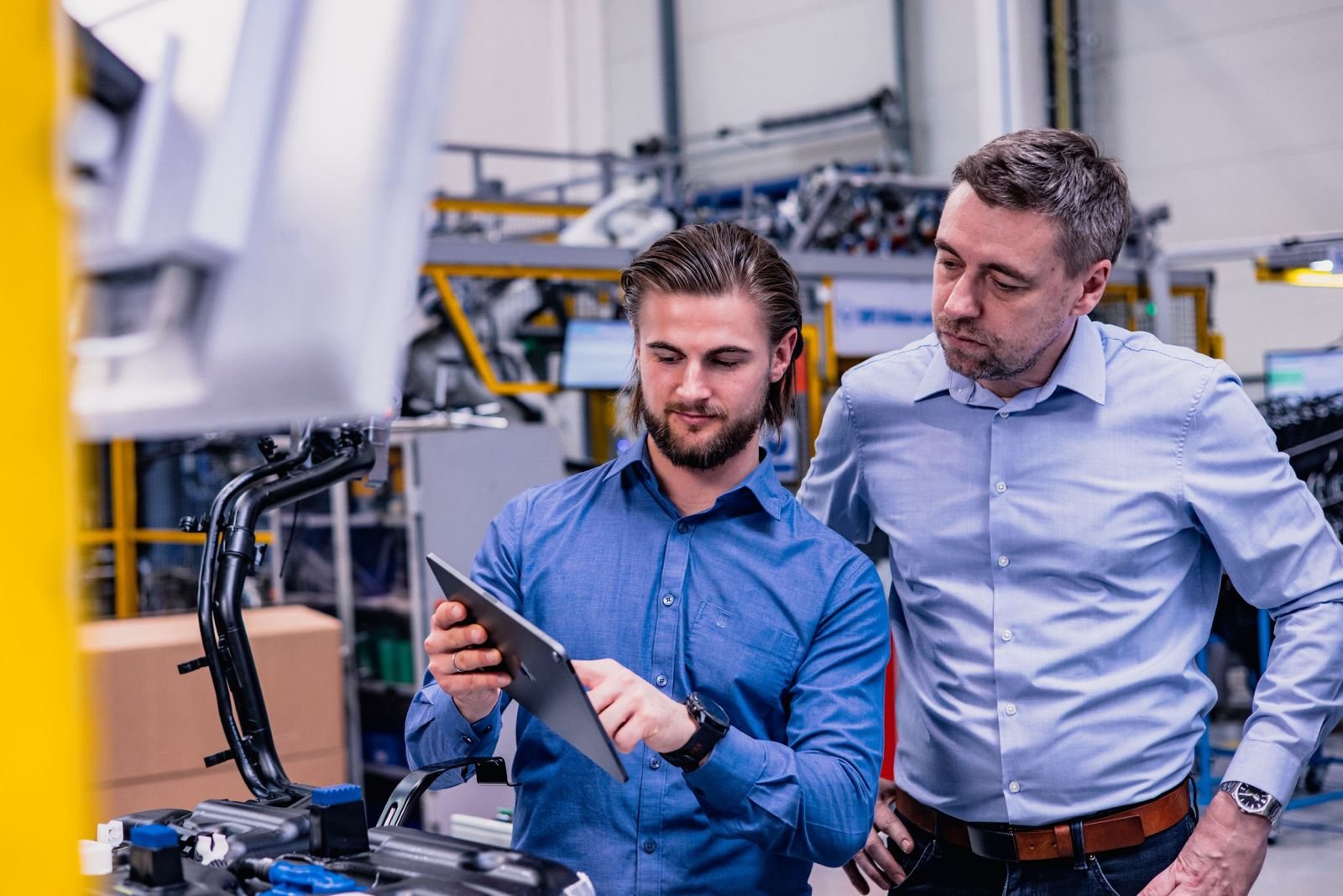 Tým s tabletem na výrobní hale